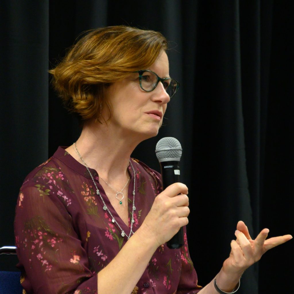 NER author Elizabeth Austen speaks into a mic