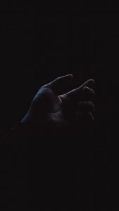  Barely visible hand reaching up in near total darkness